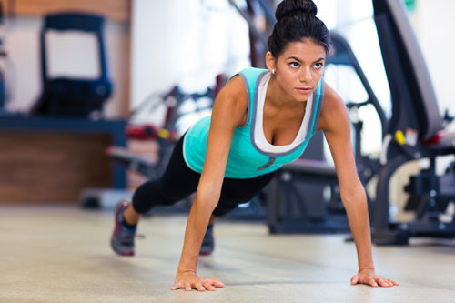 Woman in gym preparing to do pushups